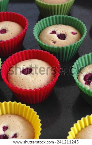 Freshly baked gluten free sponge cake muffins with raspberry and without icing.