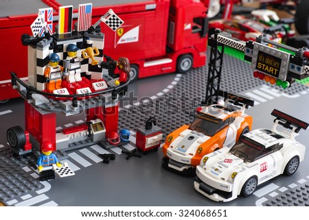 Tambov, Russian Federation - June 26, 2015 Winning podium with two drivers and photographer in Porsche 911 GT Finish Line by LEGO Speed Champions with starting lights, flag-raising function and 2 cars