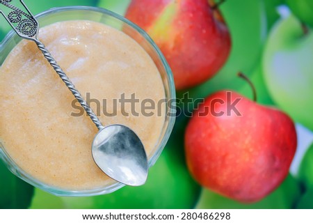 Fresh homemade apple sauce with cinnamon on the side and apple in the back. Selective focus, focus on the apple sauce.