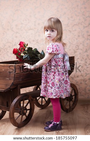 charming little girl with roses and vintage cart