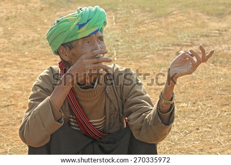 NYAUNG SHWE, MYANMAR - FEB 6, 2015: old man smoking in Myanmar countryside.