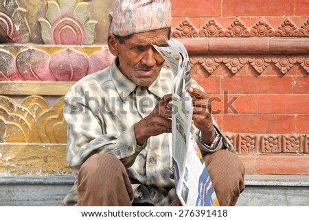 KATHMANDU, NEPAL - NOV 16, 2014: old man reading in Durbar Square in Kathmandu.