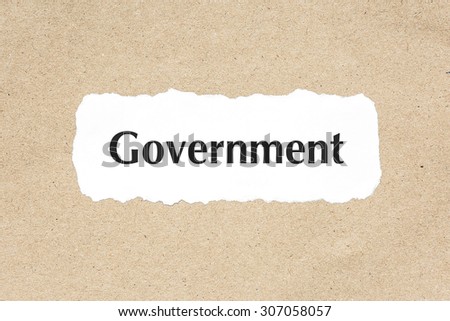 Government word on white ripped paper on brown document texture
