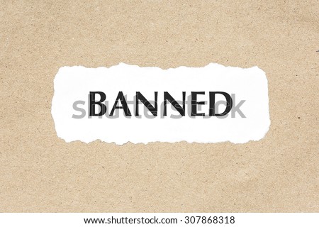 BANNED word on white ripped paper on brown document texture