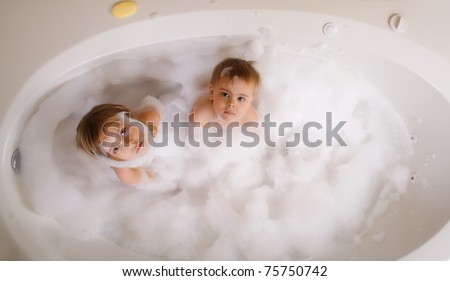 Brother and sister taking a bubble bath view from above