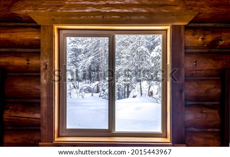 View from the window of the hut on the winter snow forest. Winter window. Window in winter snow. Winter window view