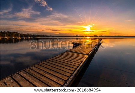 Wooden pier on the lake at sunset. Pier sunset. Sunset lake pier. Lake pier at sunset landscape