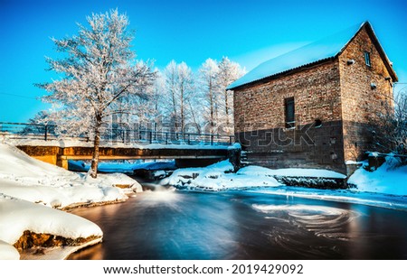 House by the river in winter snow time. Winter snow river house. Ice river in winter snow scene