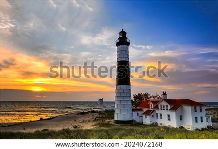 Lighthouse on the beach at sunset. Sea lighthouse at sunset. Sunset lighthouse view. Lighthouse at sunset