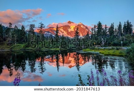 Mountain peak by the lake in the sunset. Mountain lake panorama. Mountain lake view. Sunset mountain lake