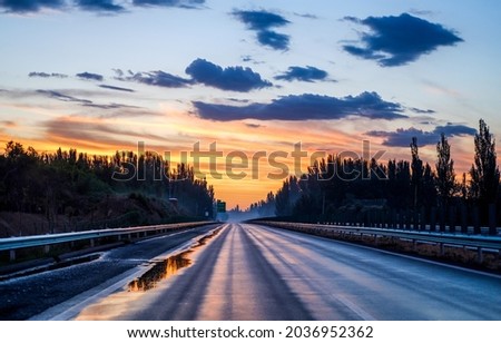 Dawn over the forest highway. Highway road at dawn. Sunrise over highway road. Road at dawn