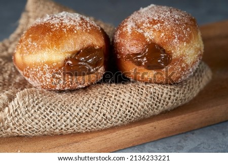 two Berliners stuffed with dulce de leche. The berliners are also known as berlin balls, bollo, bolinha or bolas de fraile Foto stock © 