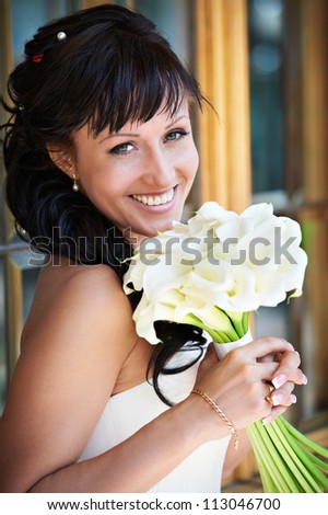 Happy bride with white wedding bouquet