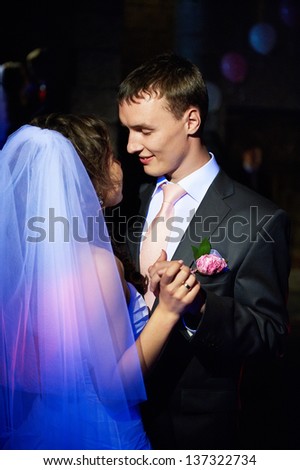 Romantic dance young bride and groom in dark banqueting hall