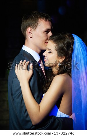 Romantic dance young bride and groom in dark banqueting hall