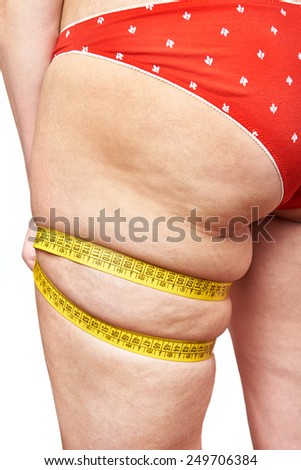 Fat woman measuring her thigh leg tape measure