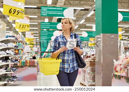 Woman housewife with list shopping in supermarket