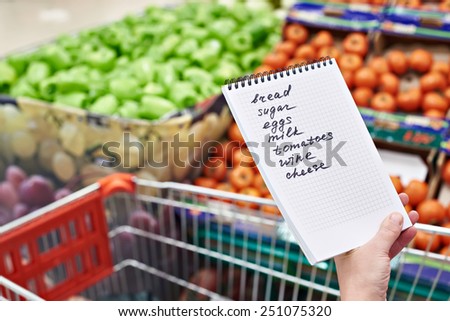 Shopping list in the hands of a woman in a supermarket