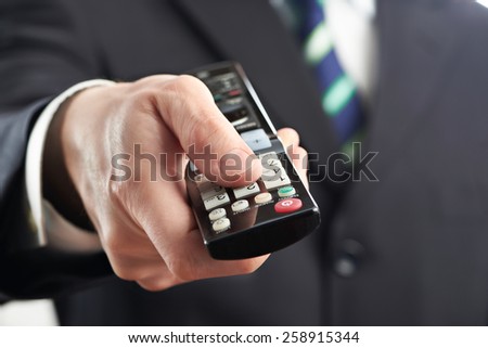 TV remote control in hand of businessman isolated on white