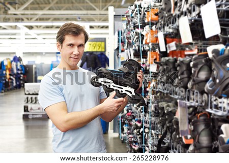 Man chooses roller skates in the sports shop