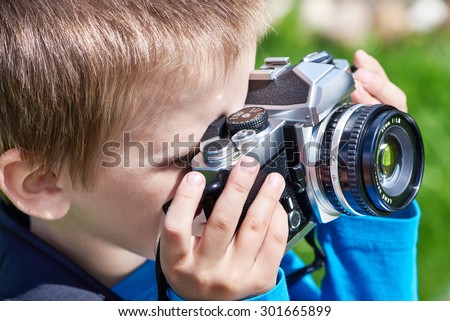 Little boy with retro SLR camera shooting