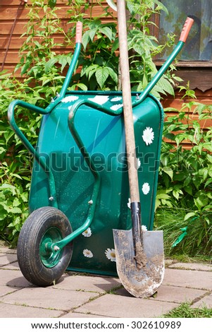 Garden wheelbarrow and a shovel in the village yard