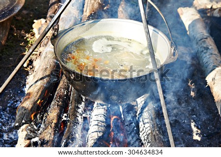 Cooking soup in the stowed bowler over a campfire
