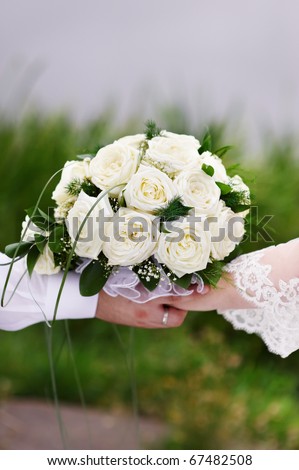 Bouquet of flowers white roses in hand of groom and bride