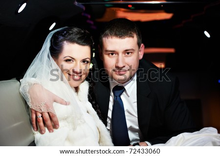 Bride and groom in a wedding limousine