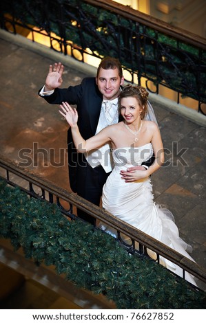 Happy bride and groom on wedding walk in beauty interior of shopping center