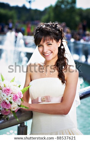 Happy bride on background of fountain in summer