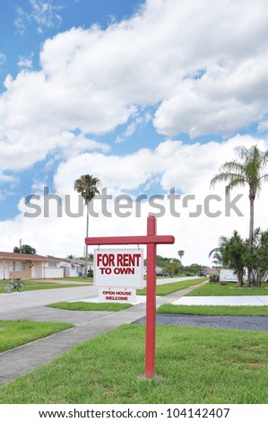 Red For Rent to Own Real Estate Sign on Front Yard Lawn of Suburban Neighborhood Residence