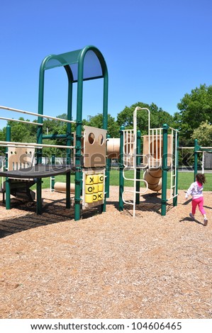 School Age five year old Girl walking to Outdoor Playground Equipment in Suburban Neighborhood Community  Park