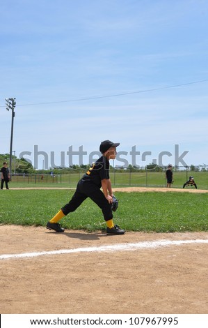 Boy Wearing Uniform Standing on Baseball Field with Teammates