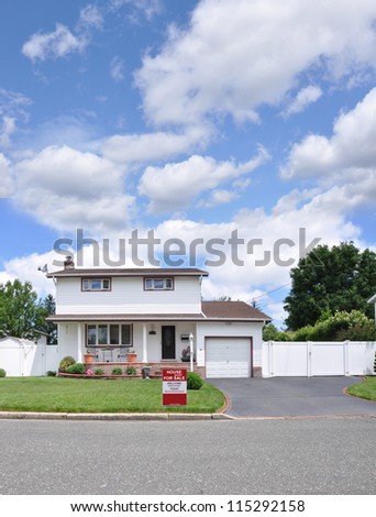 Real Estate for Sale Sign Front Yard Lawn Curb of Suburban High Ranch Home in Residential Neighborhood sunny blue sky day with clouds