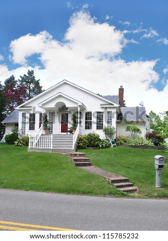 Suburban Cottage Home with Brick Steps Mailbox on curb of residential neighborhood street