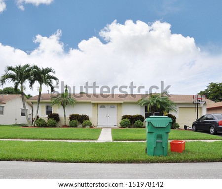 Suburban home with Trash Container on front yard lawn