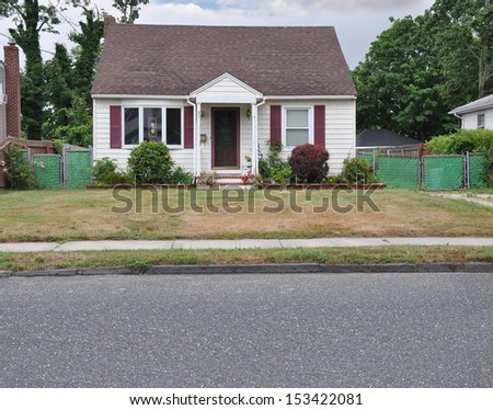 Suburban Cottage Style Home with Dry Burnt Grass Front yard lawn sidewalk curb street