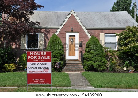 Real Estate For Sale Sign on Front Yard Lawn of Brick Suburban Home in USA
