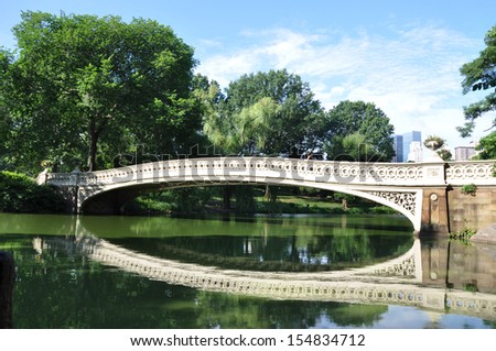 MANHATTAN, NY  - JUL 8: Bow Bridge at 74th st is the 1st cast-iron bridge in Central Park (2nd oldest in America) and it is 87 ft. long (designed by Calvert Vaux +Jacob Wrey Mould). NYC Jul 8, 2013.