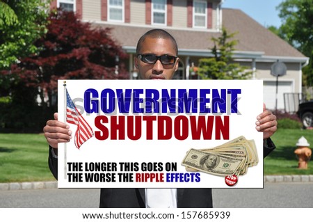 Government Shutdown Stop Payment Ripple Effects Sign in hand of African American Businessman in Suburban Neighborhood USA