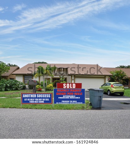 Sold Real Estate Sign Front Yard Lawn Suburban Ranch Style Home Trash Can Curbside Parked Car Residential Neighborhood USA Blue Sky Clouds
