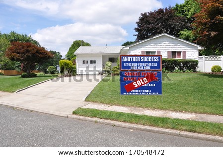 Sold Real Estate Sign (Another Success Let Us Help You Buy Sell your Next Home) Front Yard Back Split Style Suburban Home Residential Neighborhood Street USA Blue Sky Clouds