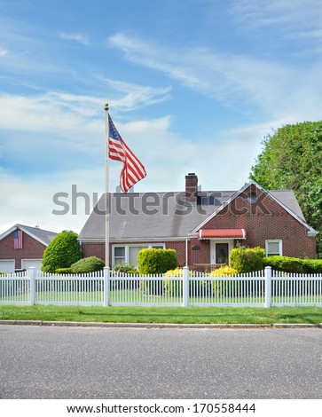 Suburban Brick Home white picket fence American Flag
