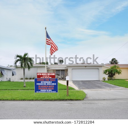 Sold Real Estate Sign \'Another Success let us help you buy sell your next home\' Suburban Ranch Style Two Car Garage Landscaped Home residential neighborhood blue sky clouds USA
