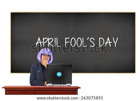April Fool's Day Classroom blackboard Teacher wearing button pin April Fools computer with #1 Prankster sticker button isolated on white background