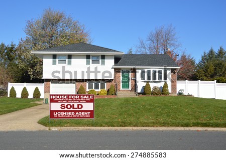 Real estate sold (another success let us help you buy sell your next home) sign Suburban Ranch home sunny clear blue sky residential neighborhood USA