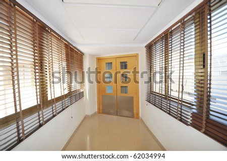 Empty Hallway leading to Two Closed Wooden Double Doors