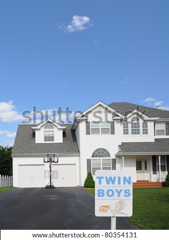 Birth Announcement Sign Twin Boys in front of Suburban Home with Basket Ball Hoop on Tar Paved Black Driveway
