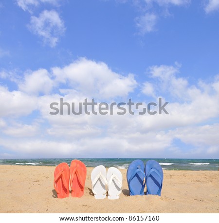 Red White and Blue Flip Flop Sandals on Sunny Beach Blue Cloud Sky